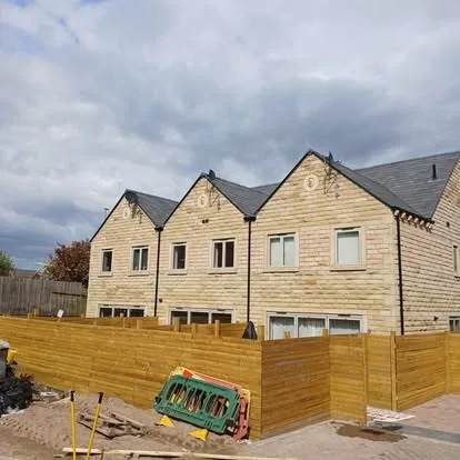 A row of new stone-built houses with aerials fitted to the roofline.